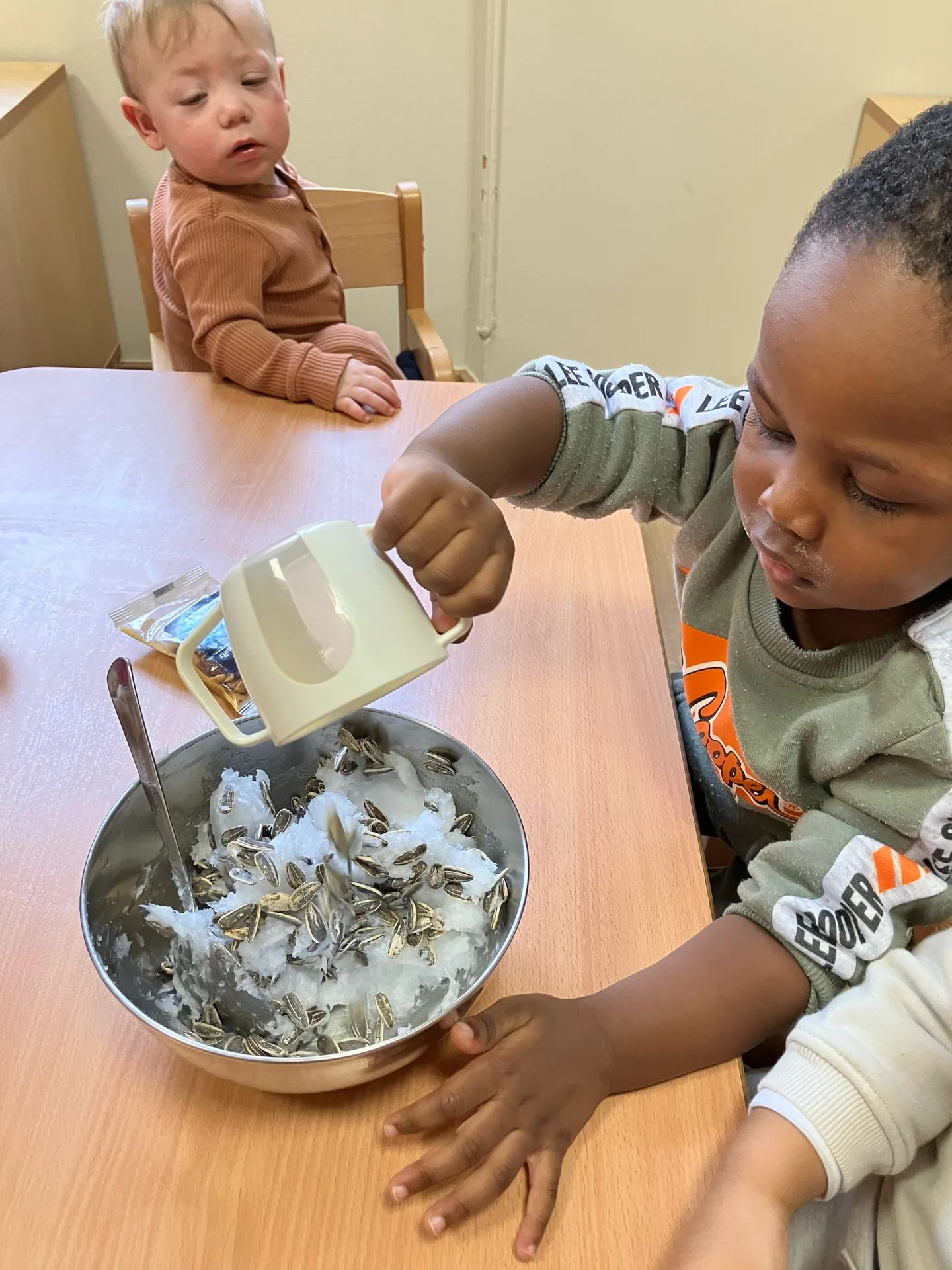 Enfants découvrent une activité sensorielle avec graines et neige artificielle à Differdange