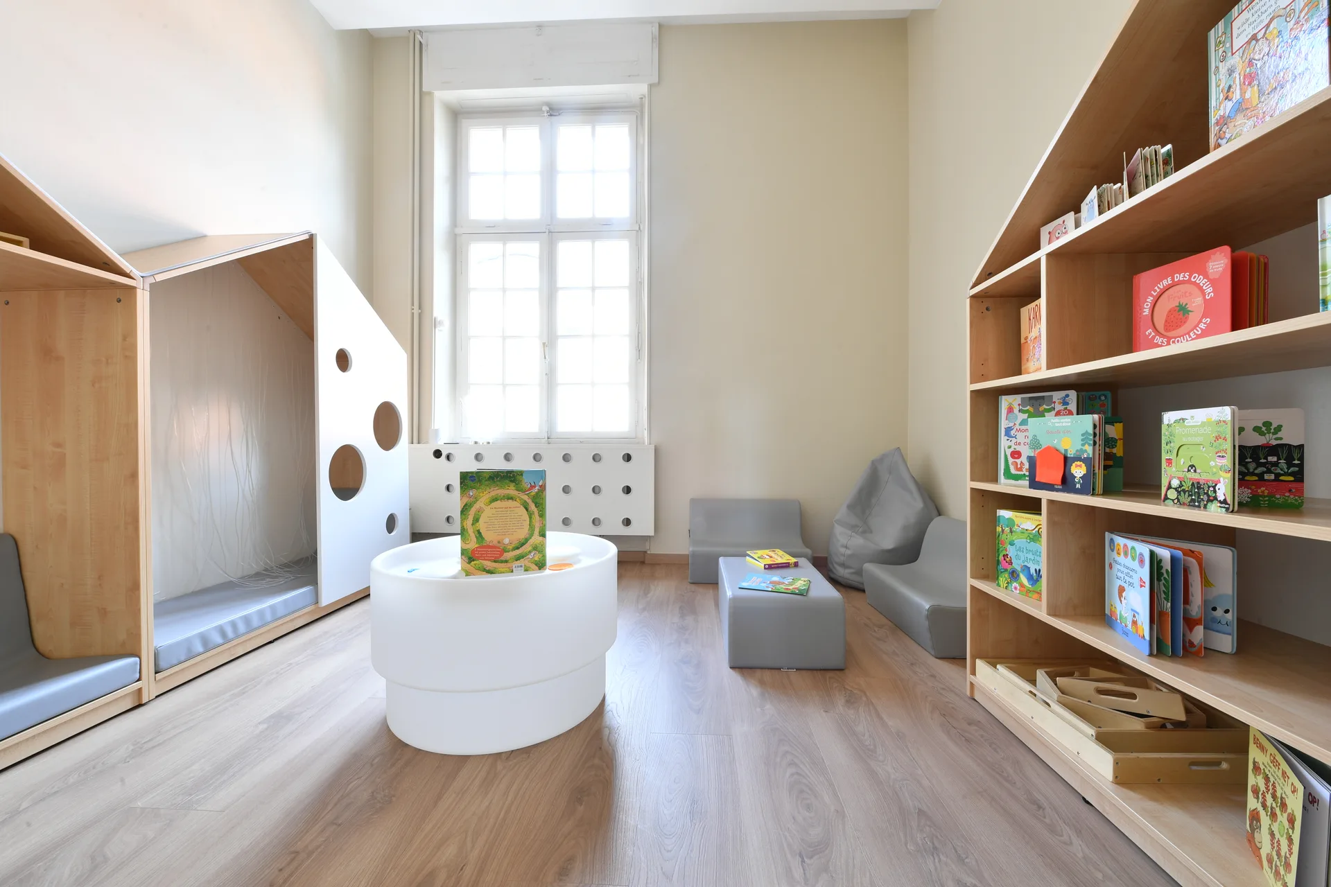 Coin lecture lumineux avec bibliothèque en forme de maison à la crèche de Differdange