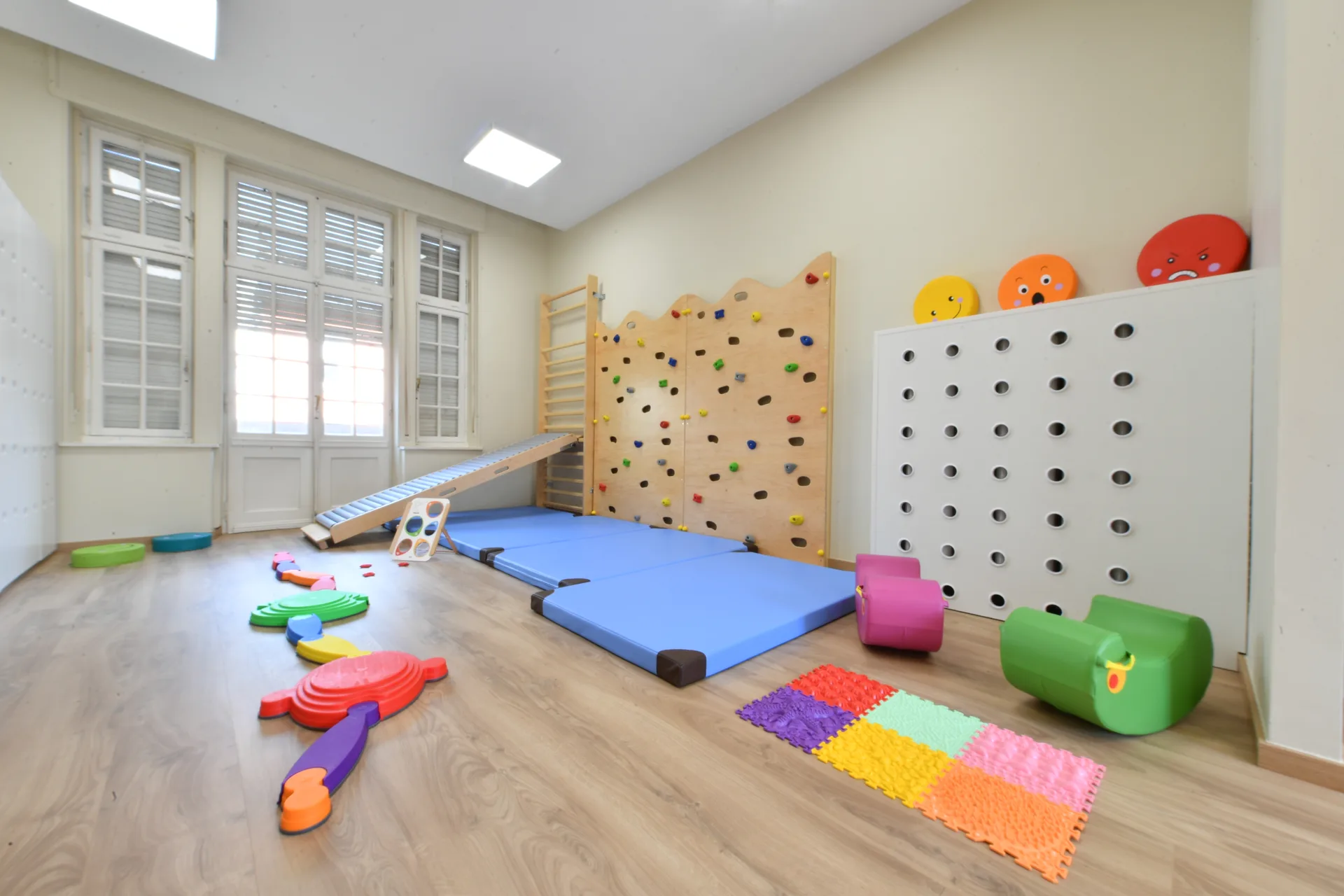 Salle de motricité avec mur d'escalade, espalier et tapis à la crèche de Differdange