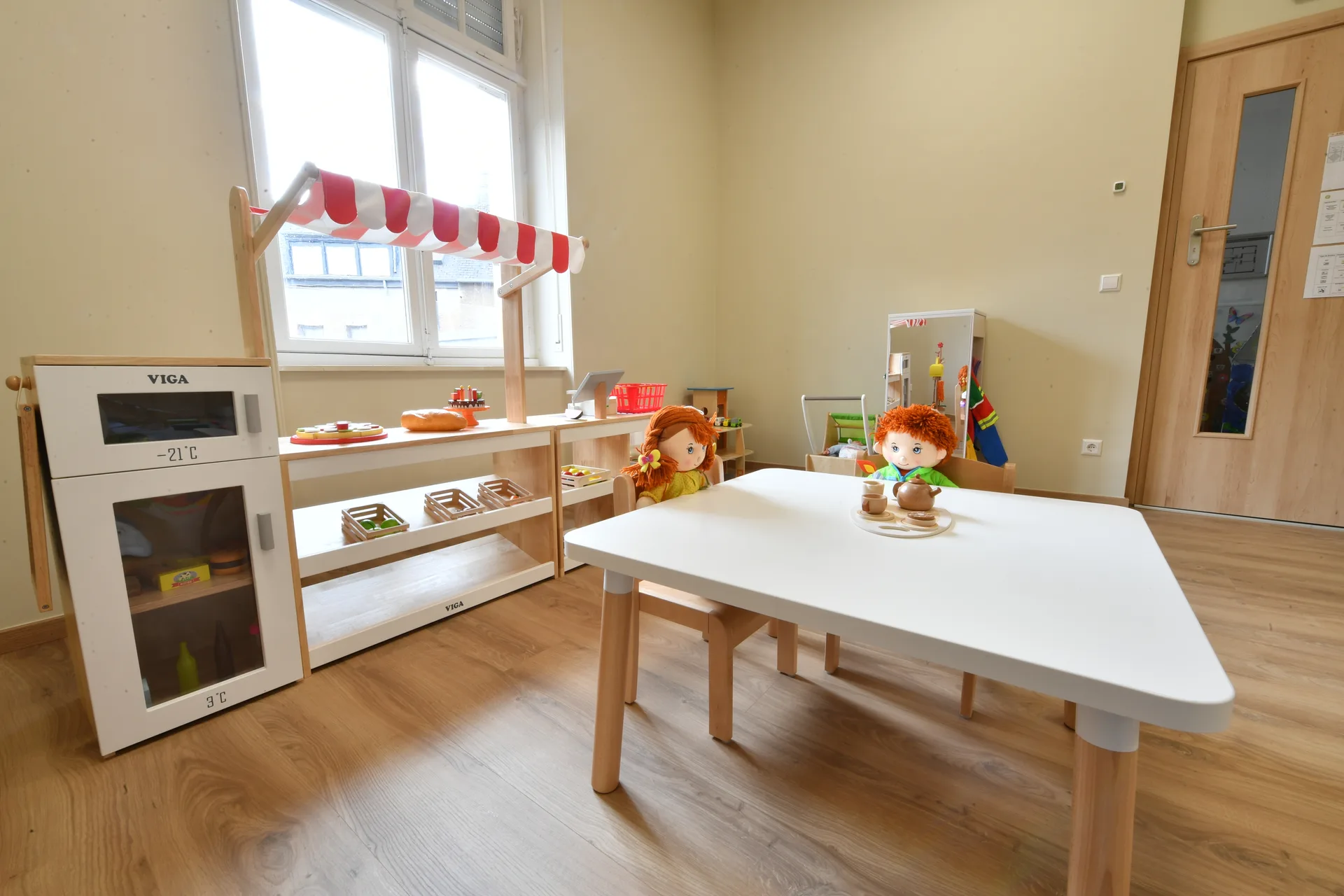 Coin dînette et marchande avec poupées et cuisine en bois à la crèche de Differdange