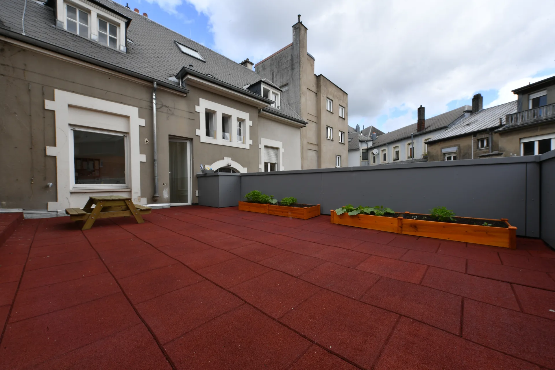 Terrasse extérieure avec bacs à potager pédagogique à la crèche de Differdange