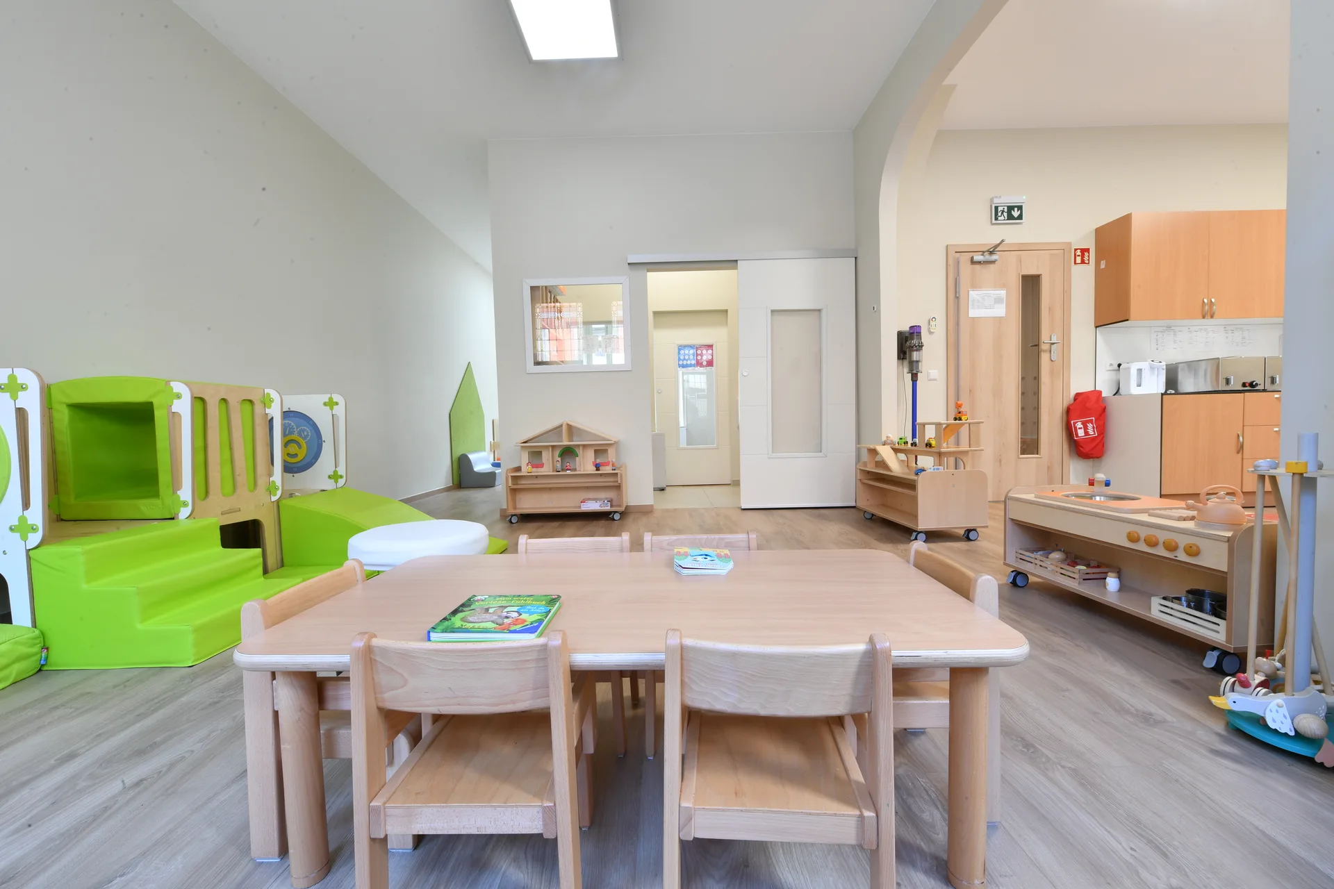 Salle de vie lumineuse avec coin repas, dînette et module de motricité à Differdange