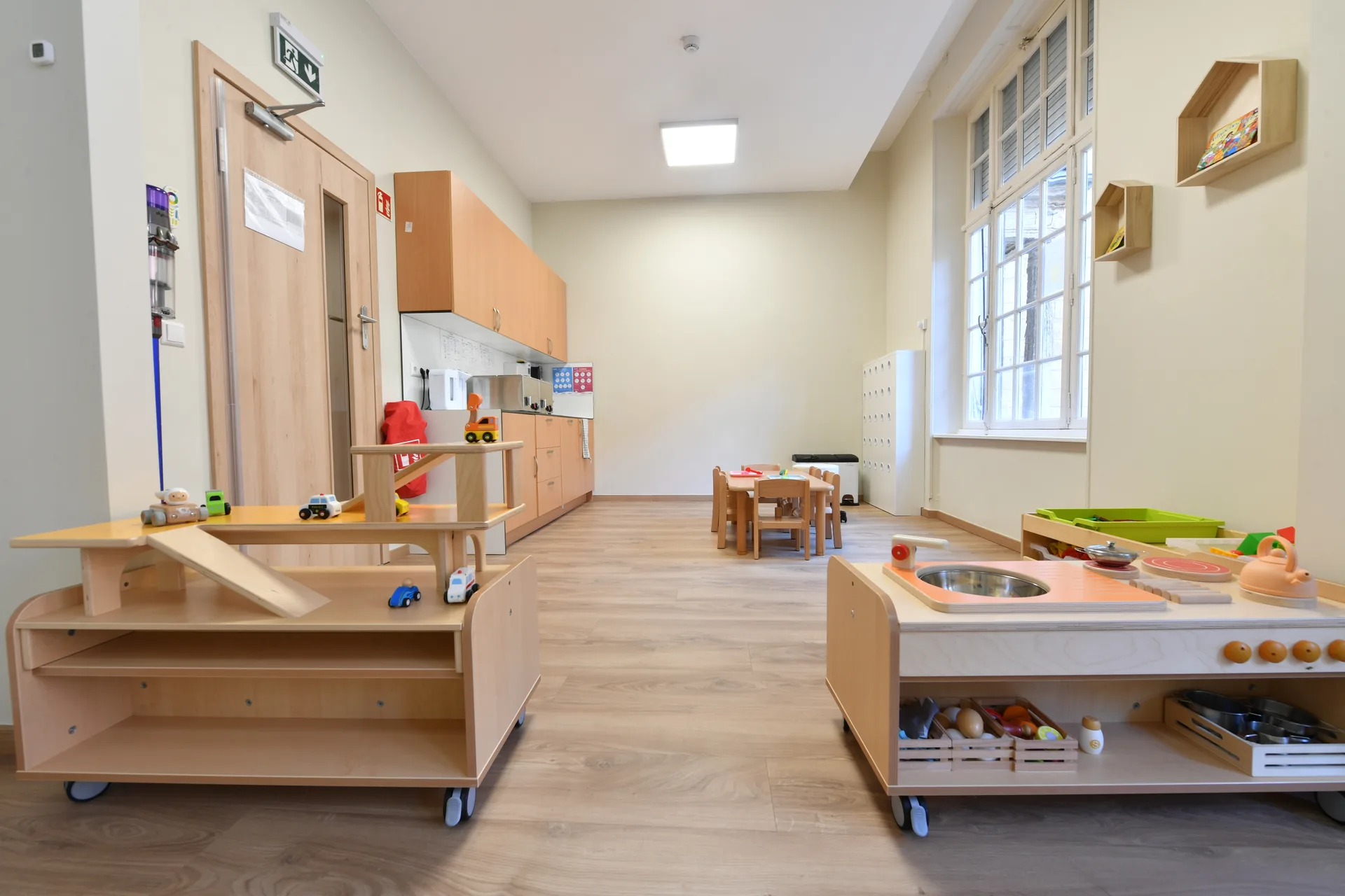 Salle de jeu spacieuse avec circuits en bois et coin lecture à la crèche de Differdange