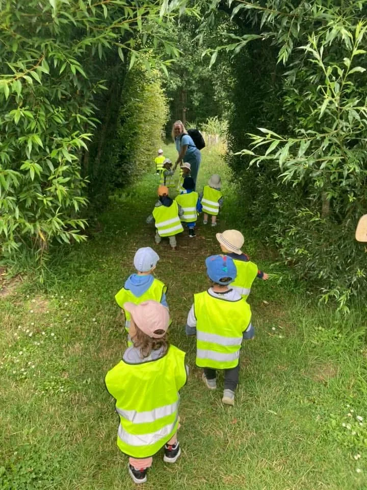 Groupe d'enfants en balade encadrée dans les allées vertes de Kockelscheuer