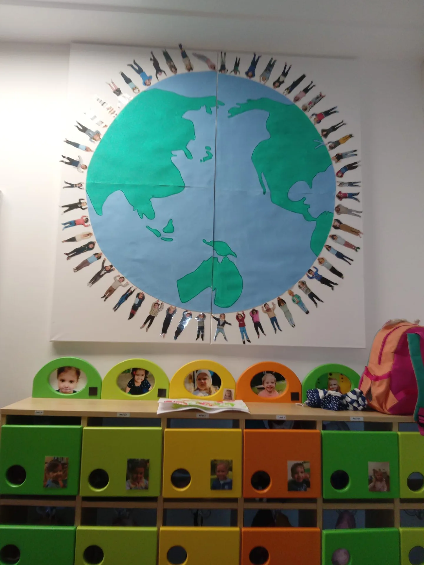 Fresque « Enfants du monde » : globe terrestre entouré des portraits des enfants de la crèche