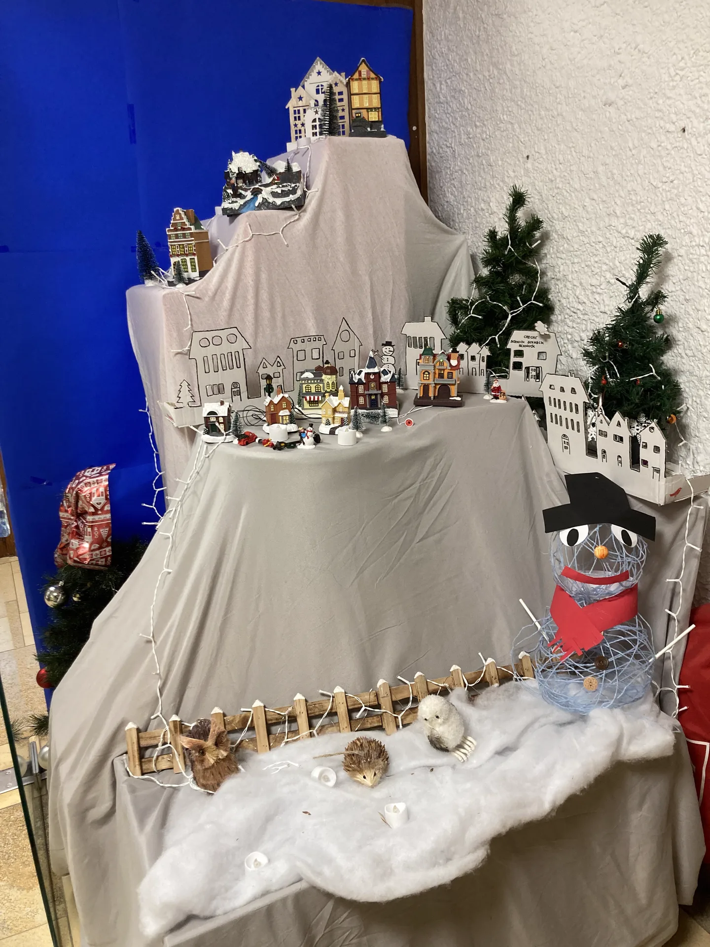 Village d'hiver et bonhomme de neige : décor de Noël réalisé avec les enfants à la crèche