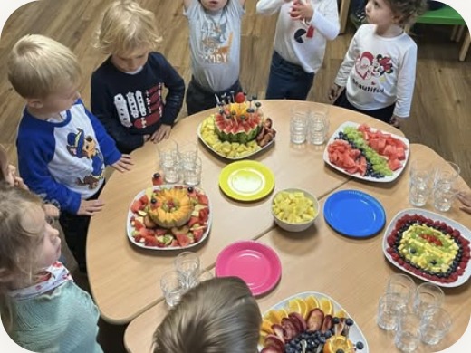 Enfants de la crèche autour de la table à la découverte des fruits